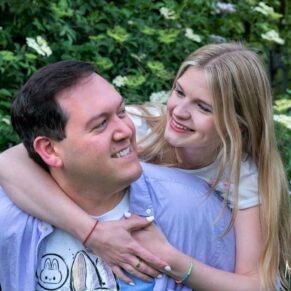 A newly engaged couple perform a piggyback in front of the camera during their Buckinghamshire photography photo-shoot portraits
