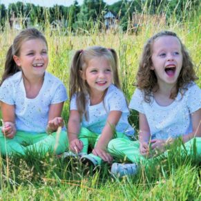 This portrait pose of three young girls sat down and giggling in the long grasses was captured in the Chilterns AONB