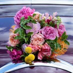 The vibrant wedding bouquet placed onto this American vintage car to create a wow impact shot at The Crazy Bear Hotel in Stadhampton