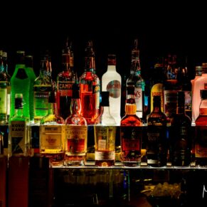 Illuminated drinks bottles for the wedding guests seen here behind the funky bar at The Crazy Bear Hotel in Stadhampton