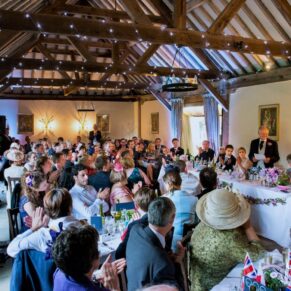 The glorious barn interior with all the wedding guests seated at this Hertfordshire venue