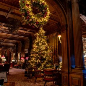 Cliveden House interior of the Great Hall decked out with Christmas decorations and a huge illuminated tree for this winter themed wedding