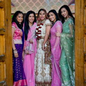 Buckinghamshire Asian Wedding Photography of brightly coloured bridesmaids arranged in a doorway