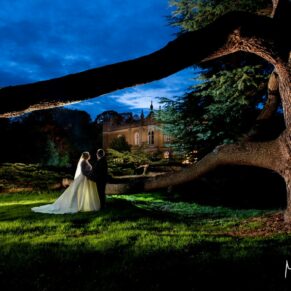The bride and groom at dusk under the 400 year old cedar tree strike a formal pose for my camera