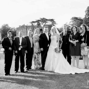Relaxed group pose of young friends on the venue's lawns during the drinks reception
