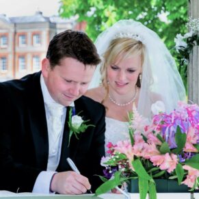 The newlyweds signing the register during their outdoor civil ceremony at this fabulous Oxfordshire wedding venue