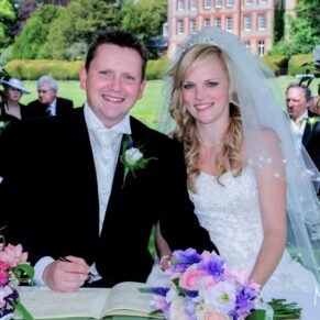 The signing of the register during the outdoor island ceremony at this couple's summer wedding