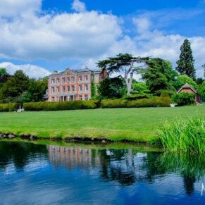 The stunning lakeside wedding venue captured across the lake in beautiful summery conditions