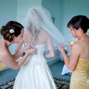 Final adjustments for the bride's gown in the bridal suite before her civil wedding ceremony