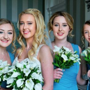 The smiling bride with her bridesmaids captured with gorgeous window lighting in the historic part of the Beaumont Estate