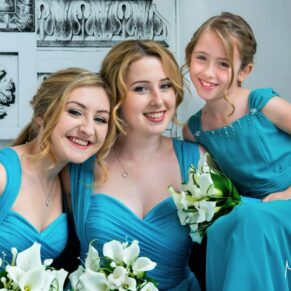 A photography close-up pose of the smiling bridesmaids captured with gorgeous window light just before the civil wedding ceremony in the grand entrance hall at the Beaumont Estate