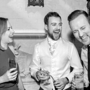 Candid and reportage Buckinghamshire wedding photographer - three guests enjoying the banter before the meal