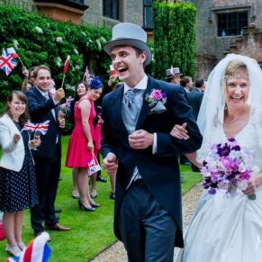 The newlyweds cheered on by their wedding guests as they arrive from the church at their relaxed Chenies Manor wedding reception