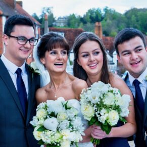 The bride with her children looking away from the camera in the grounds of the Kings Chapel in Old Amersham