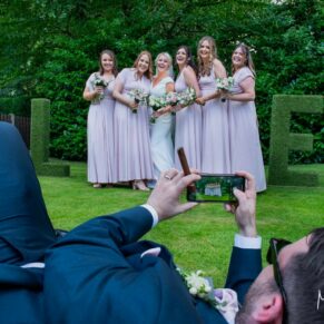 Buckinghamshire Marquee Wedding Photography - the groom has a great angle in mind for this relaxed pose of the bride with her bridesmaids
