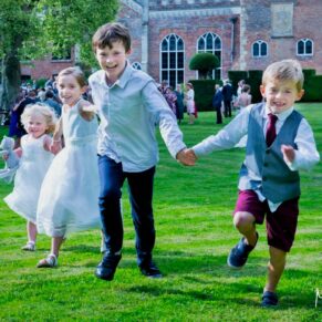 Smiling kids running at the camera in the venue's wonderful gardens