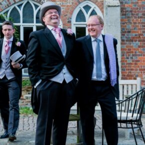 Two men laughing and giggling during the drinks reception on the venue's terrace