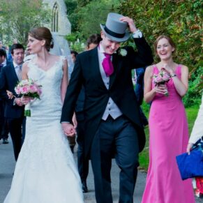 The newlyweds walk from the village church to the reception venue along the sleepy country lanes