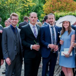 A small group of guests relaxing during the summer drinks reception in the venue's grounds