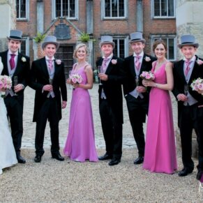 The smiling bridal party pose for my camera with the historic property behind them
