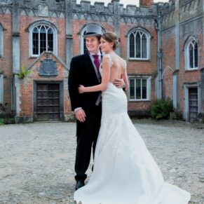 The newlyweds pose for a formal shot in the courtyard of this majestic old house