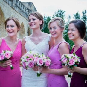 The bride with her colourful bridesmaids enjoying a giggle just after the marriage ceremony