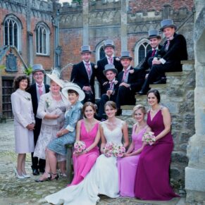 Relaxed bridal party group pose captured on the steps in the courtyard area of this historic property