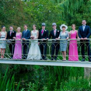 Small family group pose captured on the bridge whilst being surrounded by lush green trees