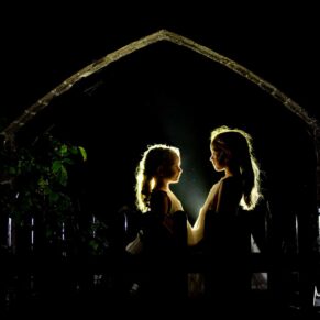 Buckinghamshire Winter Wedding Photography - silhouette portrait of two flower girls in an archway after dark