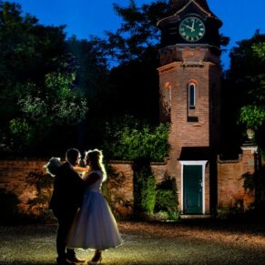 Buckinghamshire Winter Wedding Photography - the newlyweds at dusk beside the clock tower at the Tudor Barn in Burnham