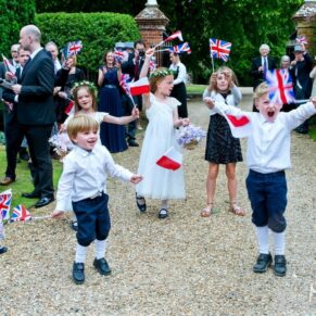 The kids loved waiving their flags to greet the newlyweds as they arrived from the church at their Chenies Manor wedding