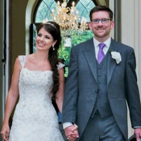 Photography of the newlyweds entering the dining room to a huge round of applause from family and friends at their Clearwell Castle wedding reception