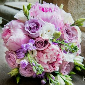 Gorgeous wedding bouquet of pinks and whites placed on the stone feature window at Clearwell Castle