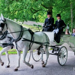 Photography of the white fairy tale wedding carriage arriving at Clearwell Castle with the newly married couple onboard
