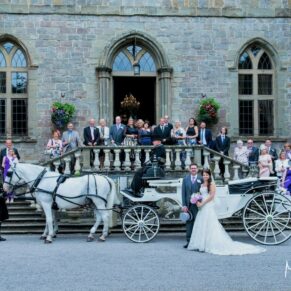 The beautiful horses and wedding carriage with everyone on the stone steps at the front of Clearwell Castle for a photography opportunity