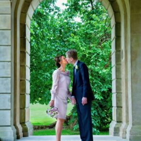 A romantic kiss for the newlyweds in the cloisters at their Cliveden House wedding