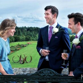 Reportage wedding photography of the couple's sons and daughter with distant views of the Cliveden House gardens from the private terrace