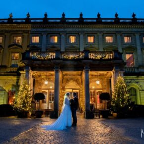 I'm particularly known for my dramatic wedding night shots, but these are elevated to another level when the backdrop is Cliveden House at Christmas! Both the interiors and exteriors at the venue offer the absolute wow factor for your wedding day. At every turn I'm spoilt for choice with photo opportunities, this particular shot was captured at the main entrance, whilst the damp cobbles just add to the drama for this pose! Photography of the newlyweds striking a pose at the front of the floodlit property under a dusky blue sky for their Cliveden House Christmas wedding
