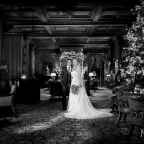 Moody black and white capture of the newlyweds in the Great Hall at Christmas