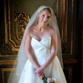 Dramatic window light portrait of the bride in the French Dining Room at their Cliveden House wedding