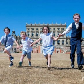 Kids running in the grounds on a scorching hot summer's wedding day with Cliveden House as the backdrop