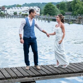 The newlyweds take a stroll on the jetty surrounded by the river during a short break from their drinks reception