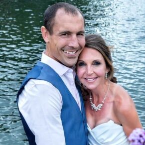 The bride and groom enjoy an embrace beside the River Thames at their Marlow Compleat Angler wedding