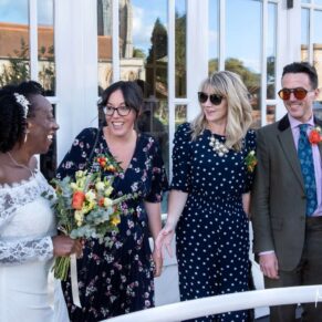 The bride captured chatting to her friends on the sunny terrace at their River Thames reception venue in Marlow