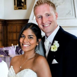 The smiling newlyweds captured in the Great Hall at Danesfield House Hotel on their wedding day