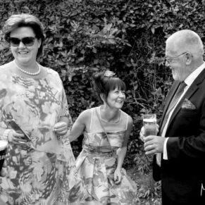 Candid moment captured during the drinks reception at Danesfield House Hotel of three wedding guests giggling away