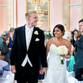 The happy bride and groom exit their wedding civil ceremony in the stunning Versailles Suite at Danesfield House Hotel