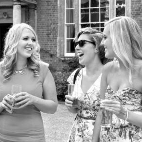 Reportage image of ladies chatting and giggling during this summer wedding drinks reception