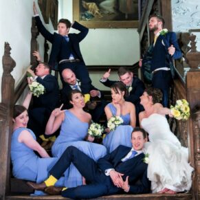 The bridal party strike a pose on the main staircase at Dorton House in Buckinghamshire