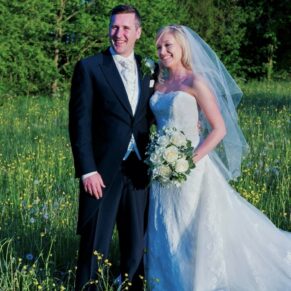 The newlyweds captured in the summer grass meadow at their gorgeous Dorton House wedding reception